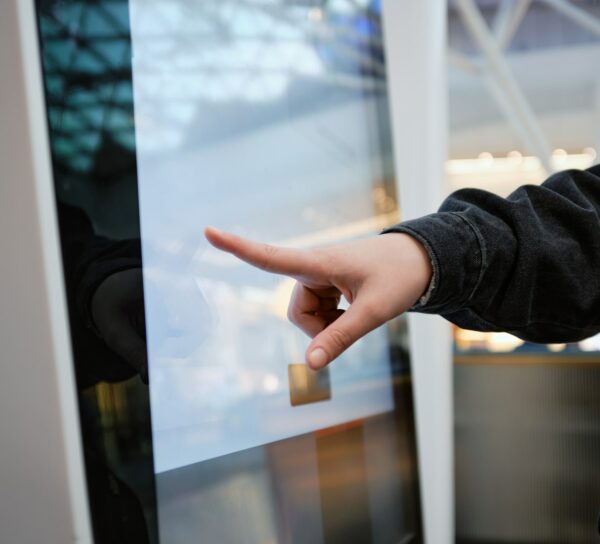 A woman is using a touchscreen directory in a mall